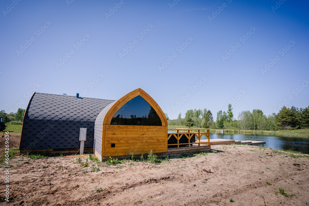 Igloo sauna made of wood with a boardwalk by the lake Igloo sauna made of wood with a boardwalk by the lake
