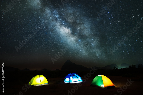 Amazing landscape of Milky Way in night sky over mountains with Camping Tent Picnic on top mountains  Adventure and outdoor travel concept
