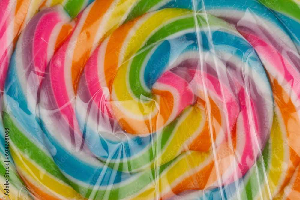 extreme closeup of colorful lollipop candy in transparent plastic packaging on white background extreme closeup of colorful lollipop candy in transparent plastic packaging on white background