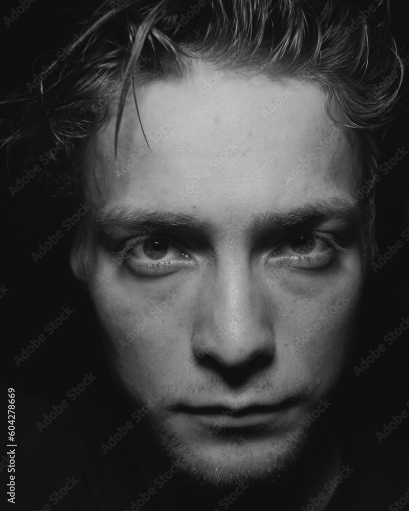 A close up of a serious man in a dark room A close up of a serious man in a dark room