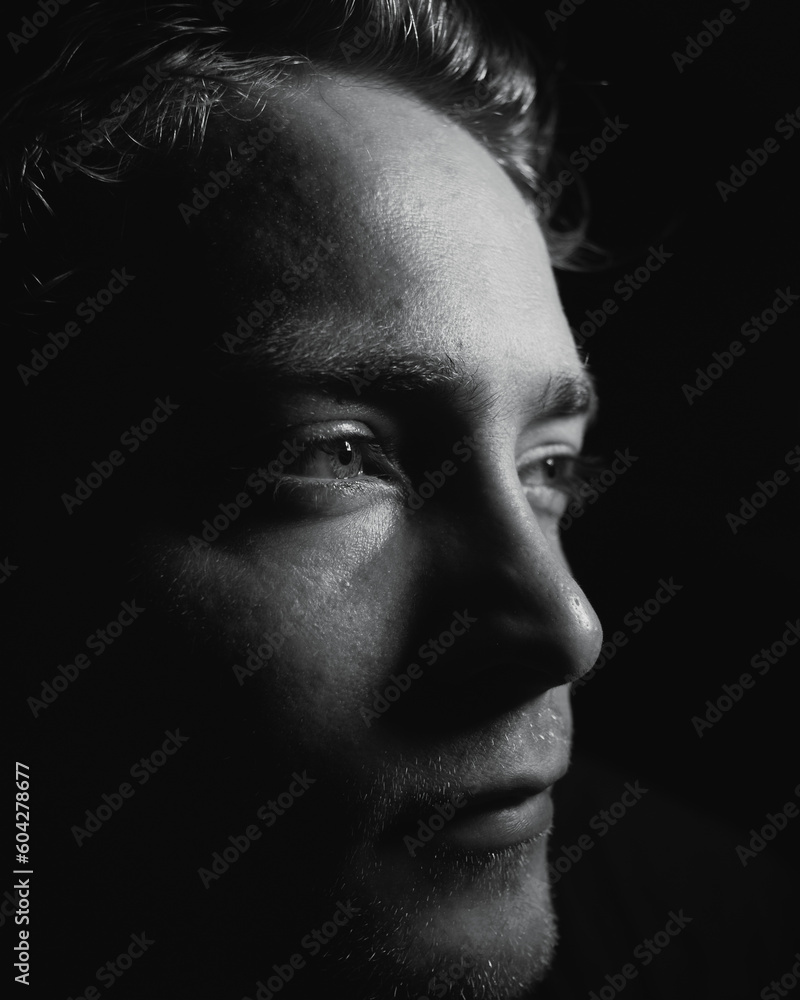 A mysterious man in a dark room being lost in thought A mysterious man in a dark room being lost in thought