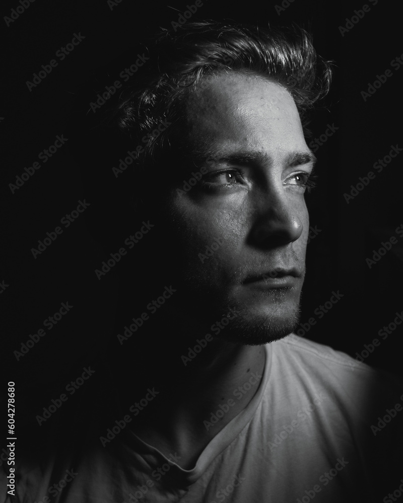 A mysterious man in a dark room being lost in thought A mysterious man in a dark room being lost in thought