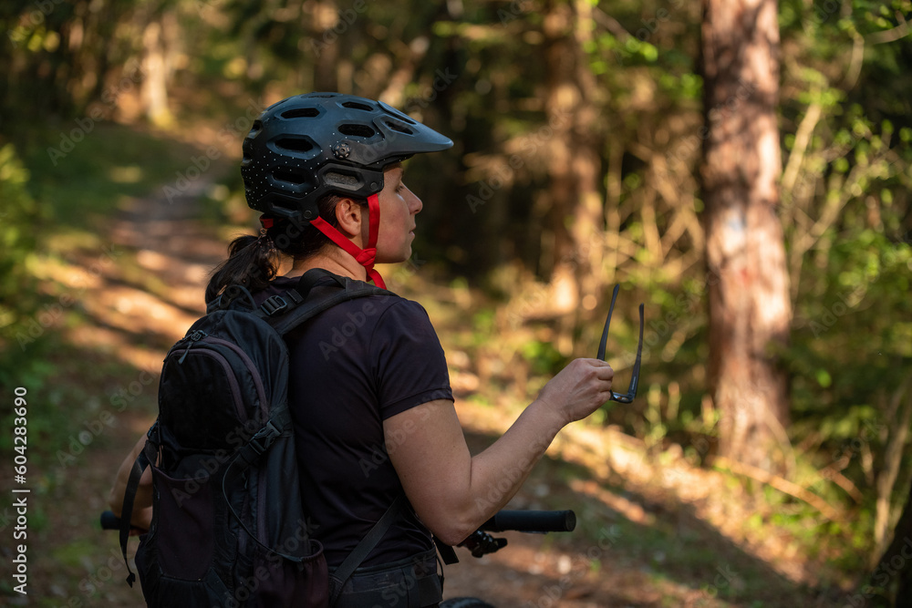 Female cyclist on her mountain bike riding through the hills on a sunny day. Female cyclist on her mountain bike riding through the hills on a sunny day.