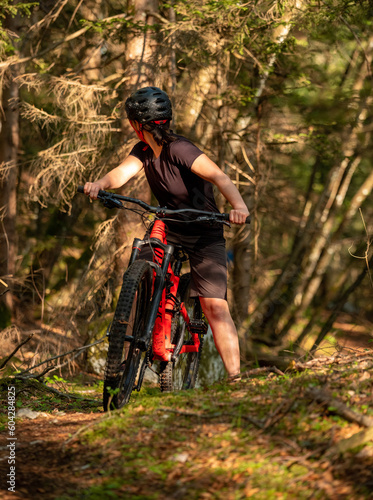 Female cyclist on her mountain bike riding through the hills on a sunny day.