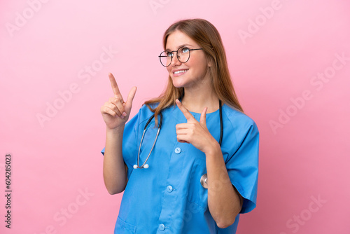 Young surgeon doctor woman isolated on pink background pointing with the index finger a great idea
