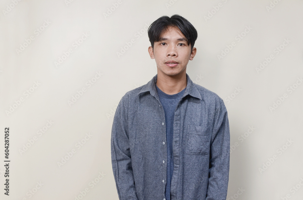 Young Age man with flat expression on isolated background Young Age man with flat expression on isolated background