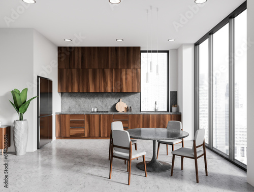 White kitchen interior with dining table and cooking space, panoramic window