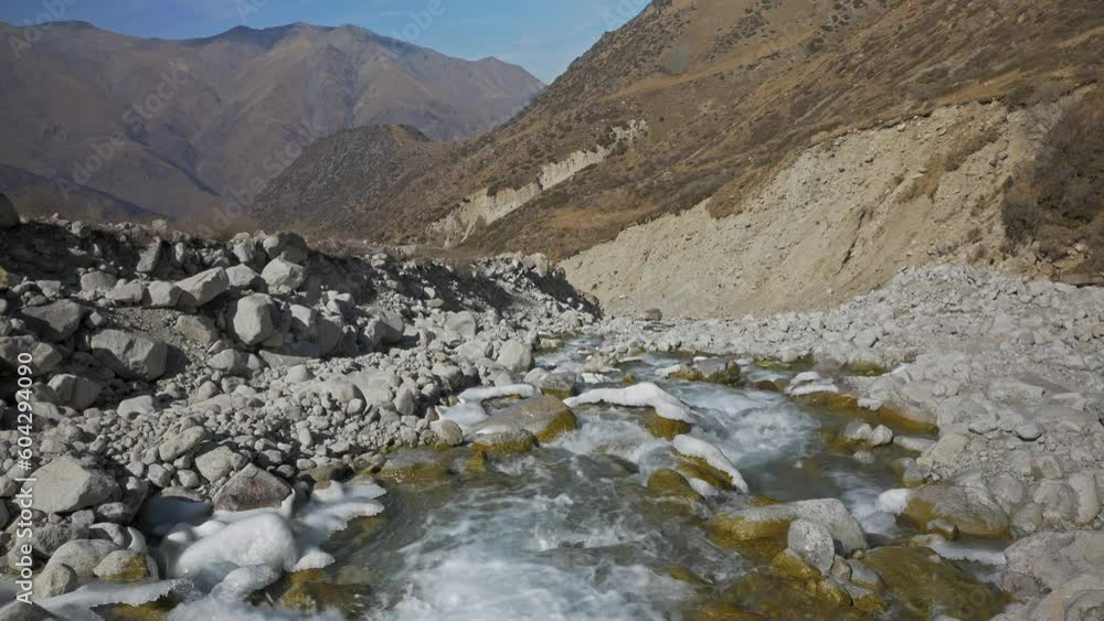 A stormy mountain river flows against the background of mountains A stormy mountain river flows against the background of mountains