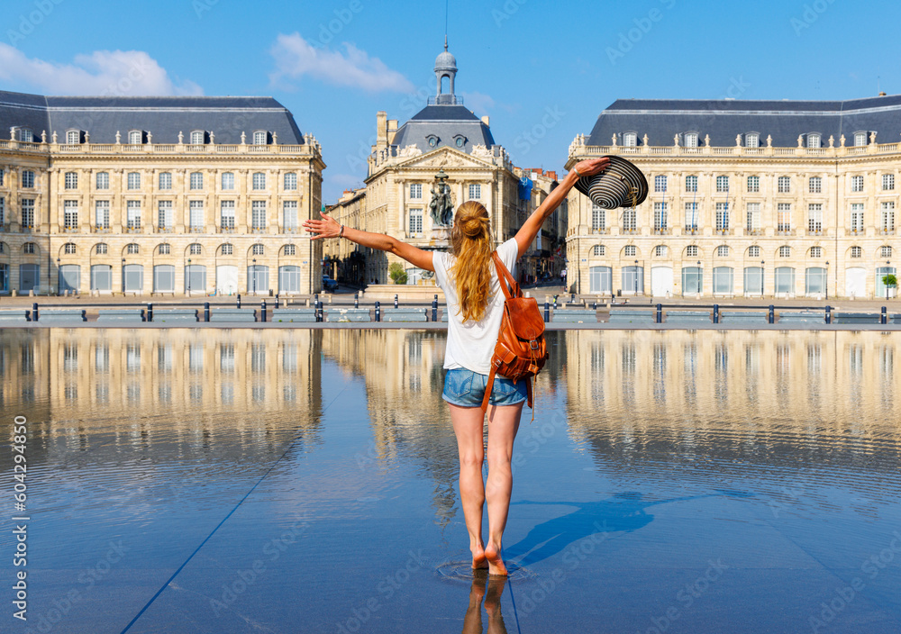 Woman traveler in France- Bordeaux city,  Bourse square with water mirror- Gironde, Nouvelle aquitaine - obrazy, fototapety, plakaty 