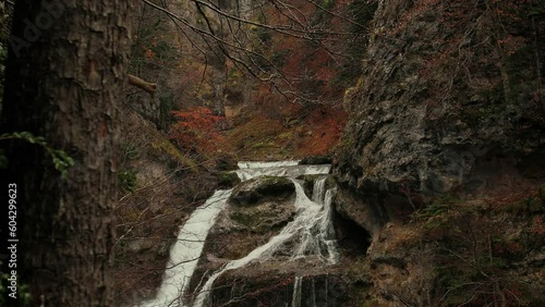 Cascada en un bosque otoñal colorido bajo la lluvia.