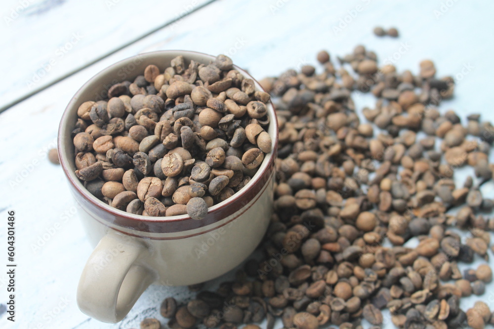 Coffee beans in cup and on table Coffee beans in cup and on table