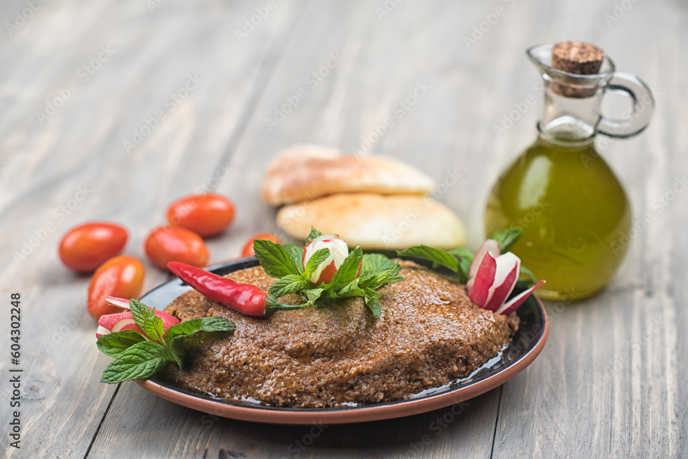 Traditional Lebanese Raw meat kibbeh with olives oil and pita bread and
