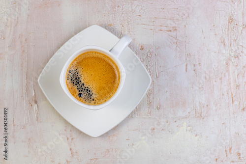 White cup of espresso on a light rustic background.