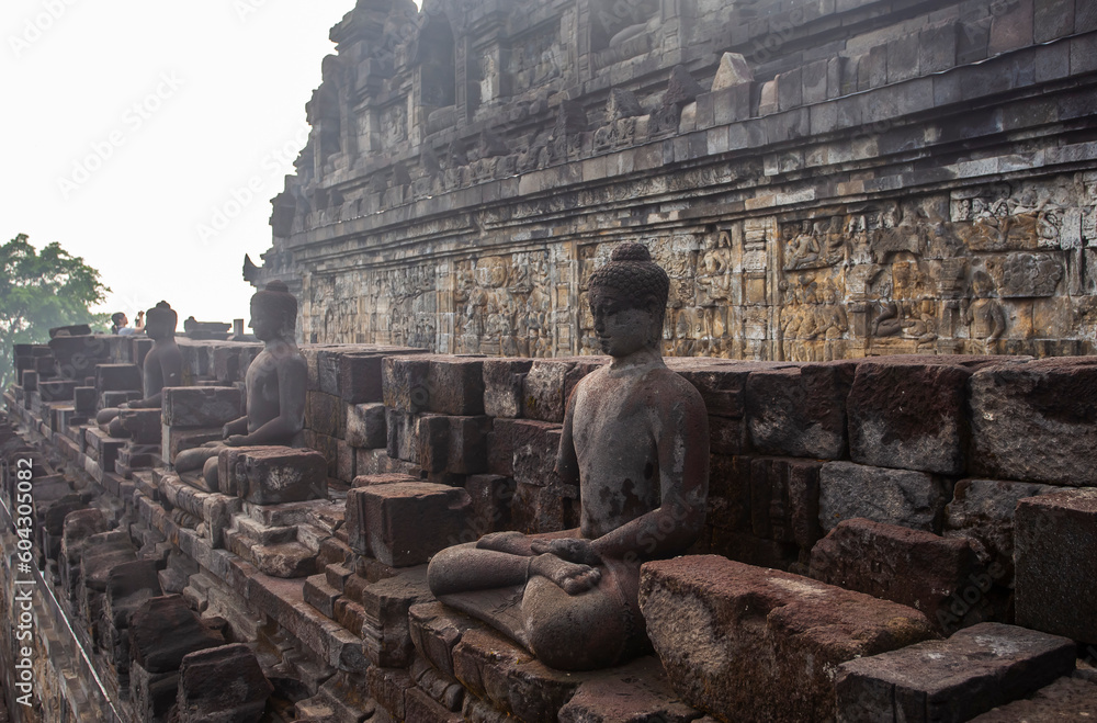 Rows of Buddhist statues and reliefs in the Borobudur Temple complex