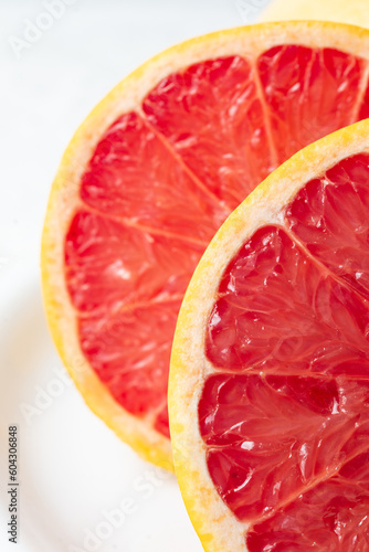 Macro close up of half a red grapefruit with selective focus, white background, vertical