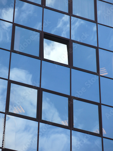 sky is reflected in the glass windows of the business center