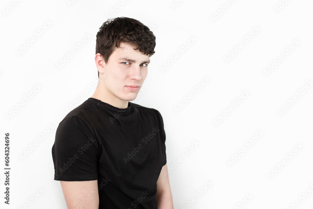 Emotions of suspicion and mistrust in a young guy, he is sad and does not trust anyone, only relies on himself, sad guy on a light background Emotions of suspicion and mistrust in a young guy, he is sad and does not trust anyone, only relies on himself, sad guy on a light background