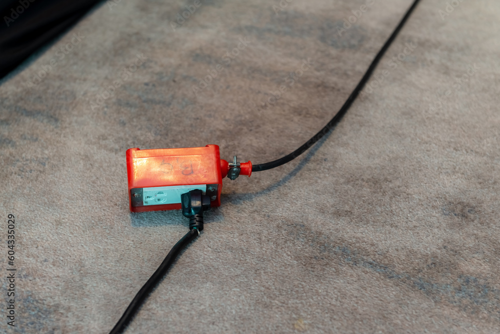 An image of a red extension cord being used on the carpet. A red