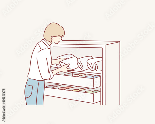 Woman folding clothes, organizing stuff in baskets and boxes. Concept of clothes storage, minimalism lifestyle. Hand drawn style vector design illustrations.