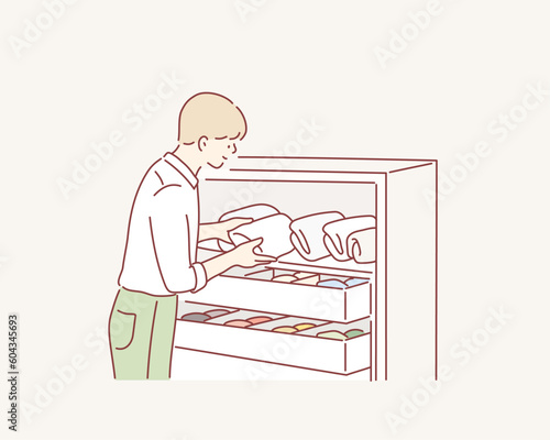 man folding clothes, organizing stuff in baskets and boxes. Concept of clothes storage, minimalism lifestyle. Hand drawn style vector design illustrations.