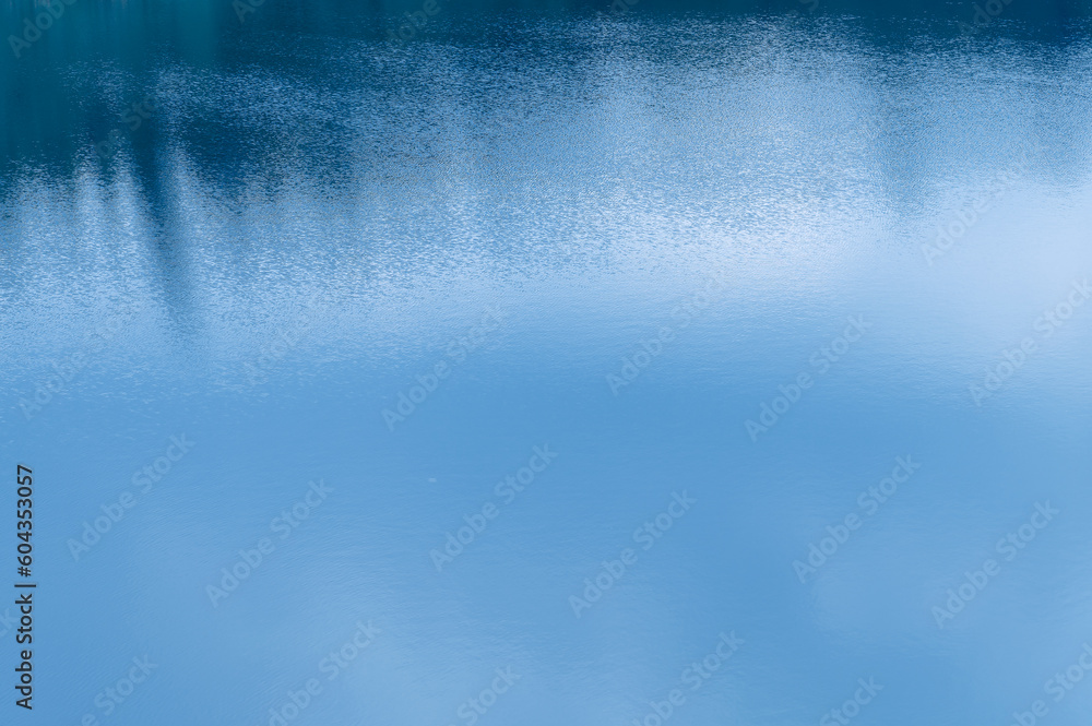 Water surface. Blue water background with soft waves. Texture of the water surface. Water surface. Blue water background with soft waves. Texture of the water surface.