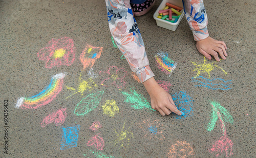 Children draw with chalk on the pavement. Selective focus.