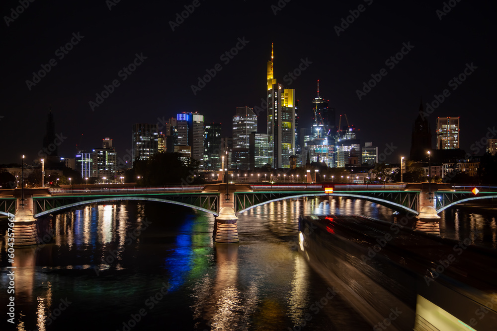 Captivating  of Frankfurt's business district skyline, a bridge illuminated by traffic, and the river with the city's reflection at night.