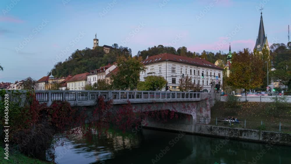 A beautiful timelapse of a clear, autumn sunset in Ljubljana, Slovenia. The historic bridge spans a calm river with old town buildings and the castle in the background. A beautiful timelapse of a clear, autumn sunset in Ljubljana, Slovenia. The historic bridge spans a calm river with old town buildings and the castle in the background.