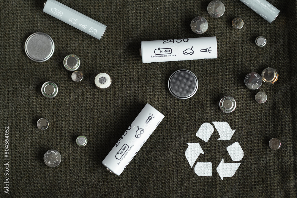 Flat lay with alkaline batteries on dark green background. Recycling