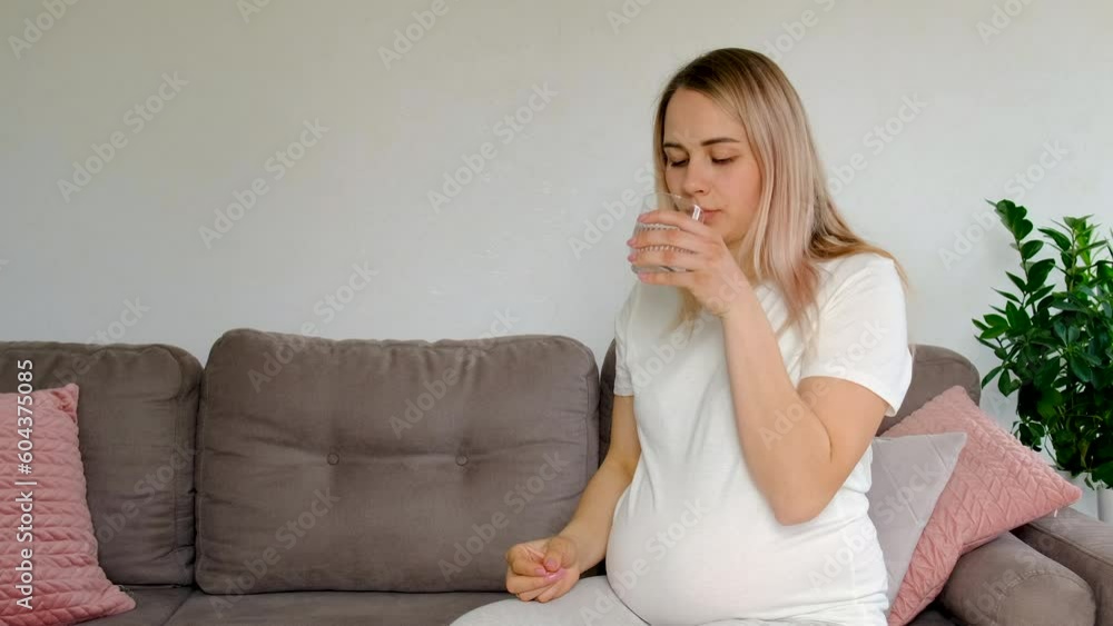 Pregnant woman drinks omega three. Selective focus. Pregnant woman drinks omega three. Selective focus.