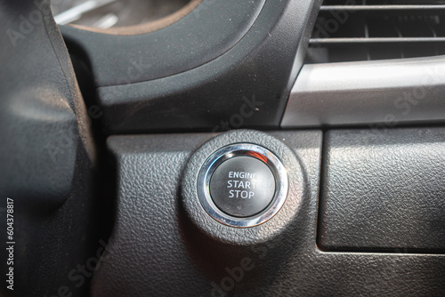 The keyless engine start button on the dashboard of modern car. Transporation object photo, close-up. © Nattawit