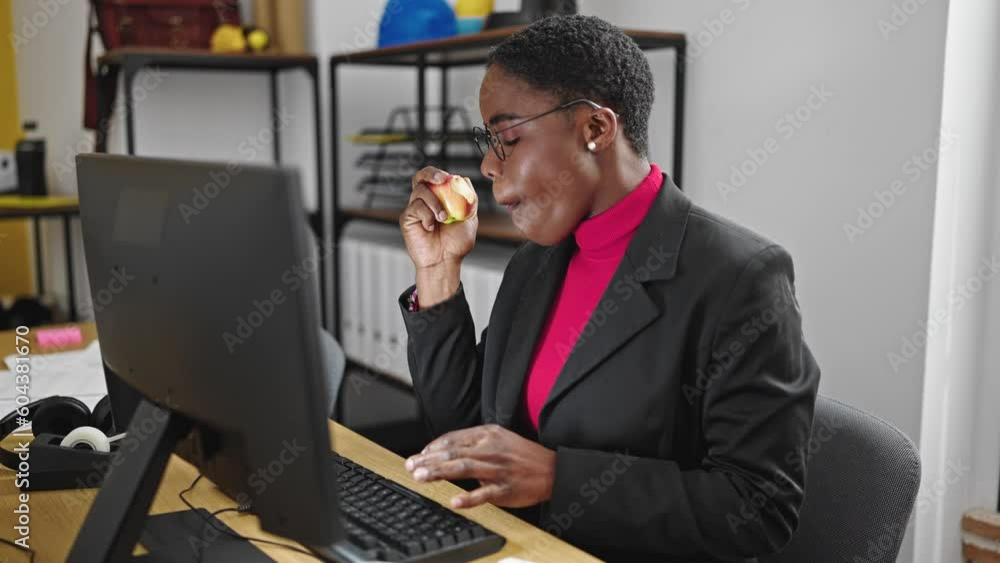 African american woman business worker using smartphone eating apple at office