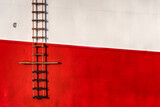 Steuerbordseite eines Schiffes obere Hälfte weiß und untere Hälfte rot links einer Leiter für Lotsen