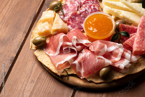 Tagliere con salame, prosciutto, pecorino e parmigiano, tipici prodotti italiani su tavolo in legno 
