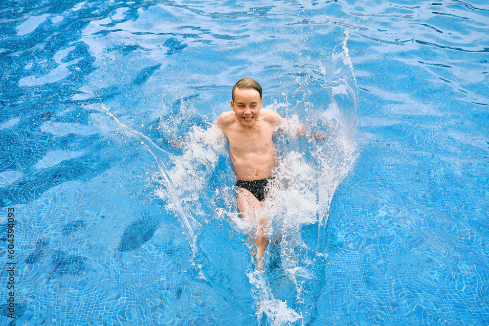 Child jump, swim in the pool outdoors, sunbathes, swimming in hot summer day. Relax, Travel, Holidays, Freedom concept.