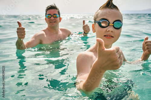 Happy family, father and son bonding, swim in the sea looking at view enjoying summer vacation. Togetherness Friendly concept  © Andrii IURLOV