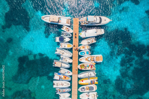 Leinwand Poster Aerial view of boats and luxure yachts in dock at sunset in summer in Sardinia, Italy