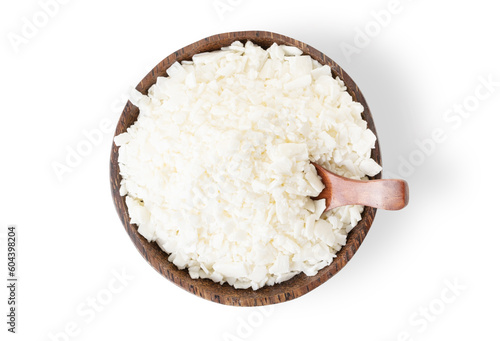 Organic white soy wax flakes for candles in coconut bowl isolated on white background