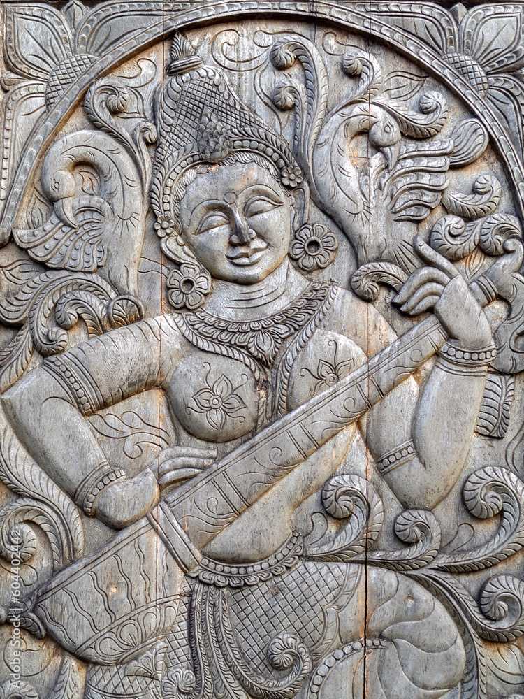 Carved figure of Saraswati on a wood