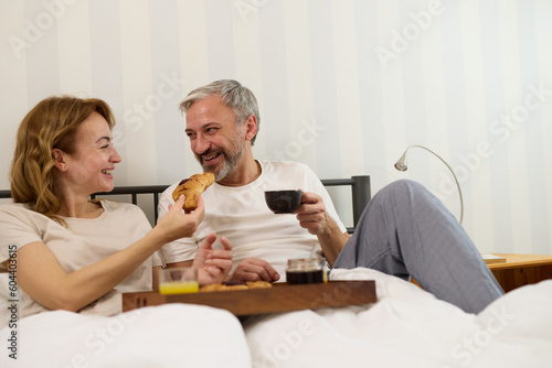 Mature couple enjoying coffee and breakfast at home in bed © Stockphotodirectors