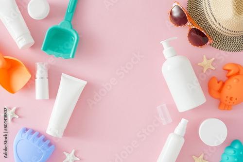 Children's summer skin care concept. Top view flat lay of cosmetic bottles, sunhat, starfish, kids summer accessories, and sunglasses on light pink background with empty area for text or advert