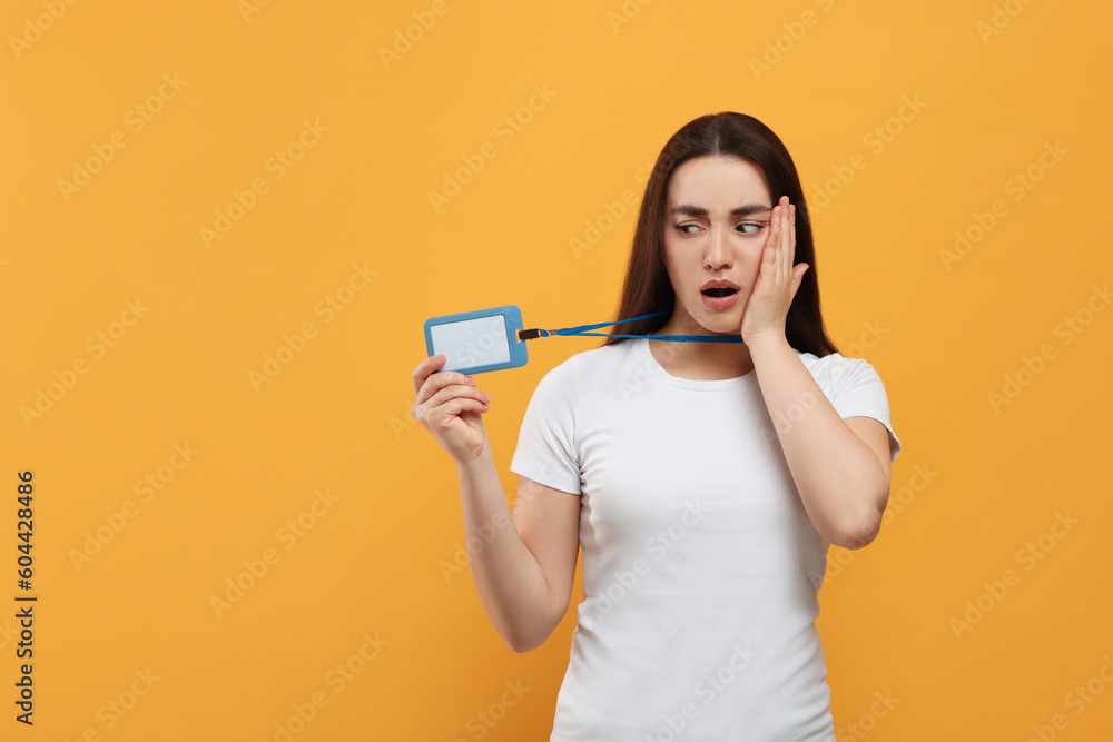 Worried woman with vip pass badge on orange background. Space for text Worried woman with vip pass badge on orange background. Space for text