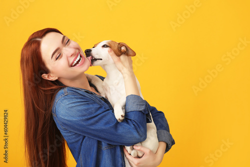 Photo Happy woman with her cute Jack Russell Terrier dog on orange background