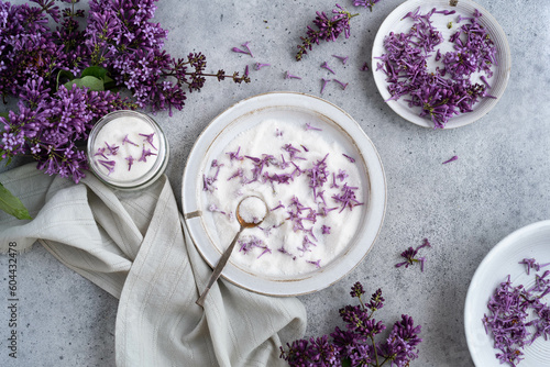 Sugar, achromatized with lilac flowers, for home baking. On a marbled gray background, top view. 