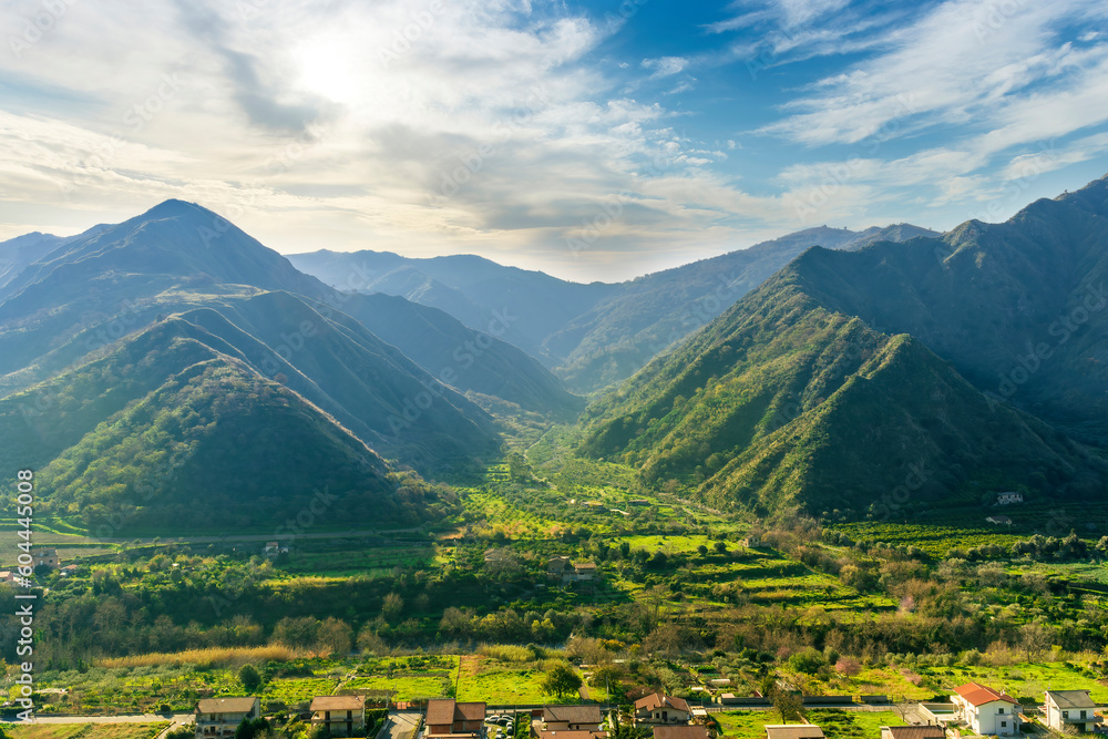 landscape of green summer highland mountain range with green beautiful valley below and amazing blue cloudy sky landscape of green summer highland mountain range with green beautiful valley below and amazing blue cloudy sky