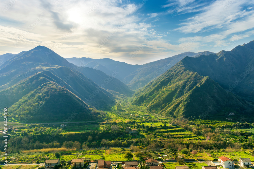 landscape of green summer highland mountain range with green beautiful valley below and amazing blue cloudy sky