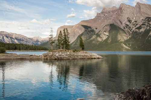 Mountain lake in the Rocky Mountains of Canada. Small island with pine trees, clear lake water reflection and stone coast. Amazing colors of nature The concept of active and photo tourism