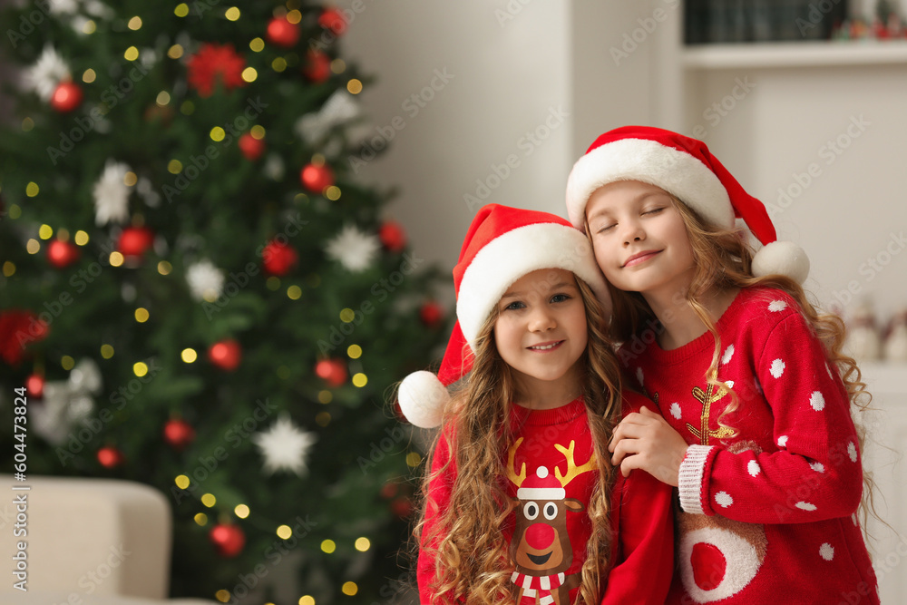 Cute little girls near Christmas tree at home. Space for text Cute little girls near Christmas tree at home. Space for text