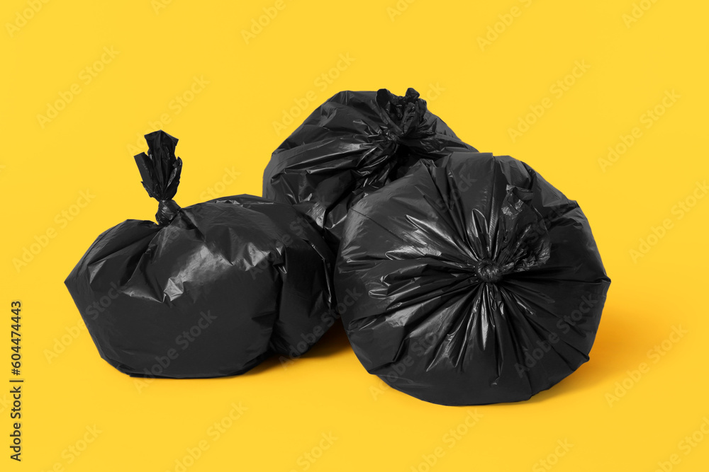 Trash bags full of garbage on orange background Trash bags full of garbage on orange background