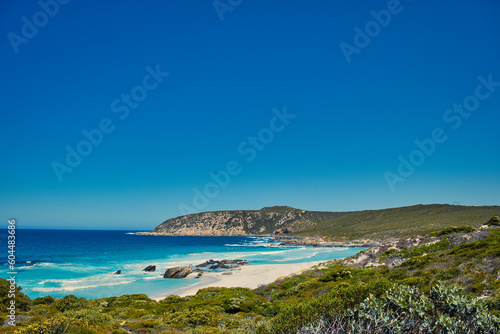 Azure blue sea, rocky hills and low coastal vegetation: West Beach, along the Hakea Trail in Fitzgerald River National Park, south coast of Western Australia. 